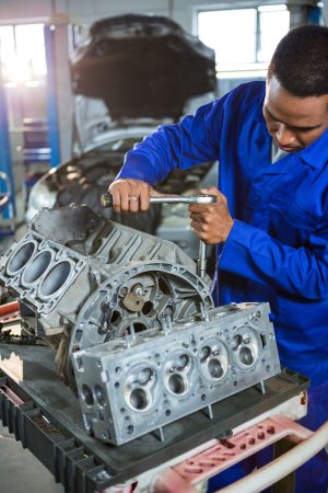 Mechanic repairing engine part with ratchet at the repair garage
